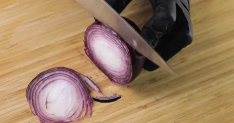 Chef in gloves cooking cutting fresh red onion on wooden board, hands closeup. Stock Footage 147347778