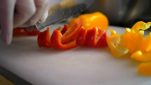 Chef in gloves cuts paprika on cutting board. Healthy vegetarian food Stock Footage 150833039