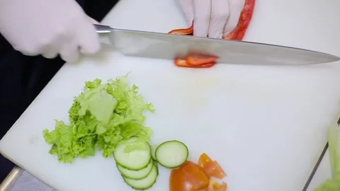 Chef with gloves cuts pepper Stock Footage 70171621