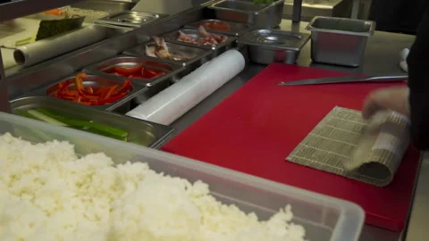 A Chef in gloves is making the Sushi Rolls using culinary rice as the base Stock Footage 158284200
