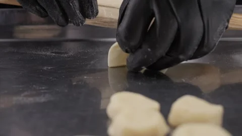 A chef with gloves rolls out the dough on the table. Stock Footage 307734501