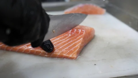 Chef with Gloves Slicing Salmon Stock Footage 128927434