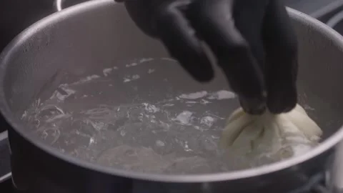 Chef in gloves throws khinkali into saucepan of boiling water. Stock Footage 316512780