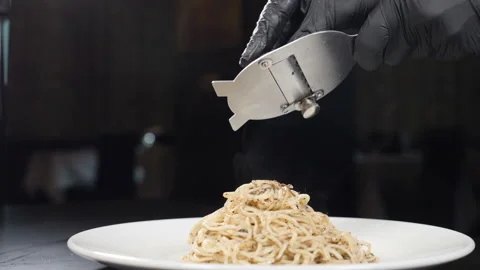 Chef grates black truffle on pasta in Italian restaurant. Slow motion. Concept Stock Footage 140573761