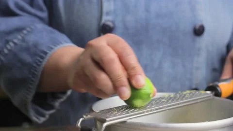 A chef grates a lime in order to bake a mexican Pan de Muerto Stock Footage 161855129