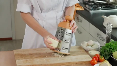 The chef grates mozzarella cheese on a coarse grater Stock Footage 266317814