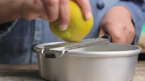 A chef grates an orange in order to bake a mexican Pan de Muerto Stock Footage 161855153