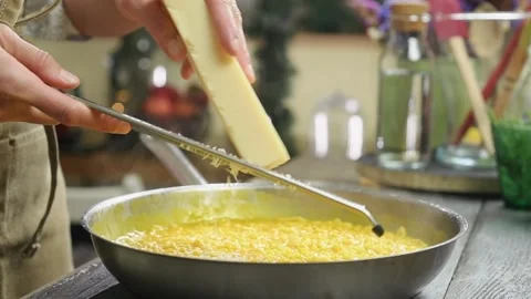 The chef grates parmesan into the frying pan with pumpkin risotto. Stock Footage 207018409
