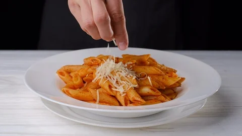 Chef grating cheese parmesan on pasta penne In white plate Stock-Footage 121559811