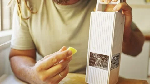 Chef grating ginger with a manual grater in the kitchen Stock Footage 307995253