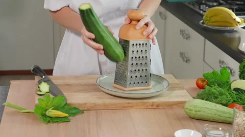 Chef grating green zucchini on a fine grater Stock Footage 270149822