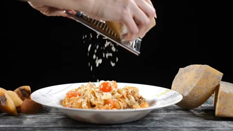Chef grating hard cheese. Cooking seafood pasta. Slow motion of A cook grater Stock Footage 102650875