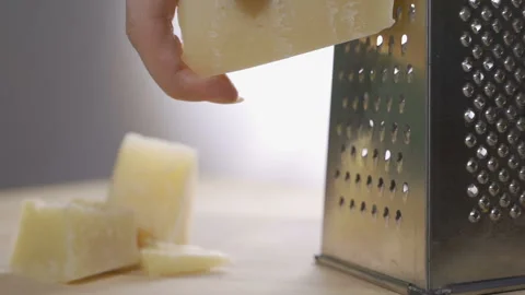 Chef grating Italian parmesan cheese with metal grater in the kitchen, slow Video stock 105809136