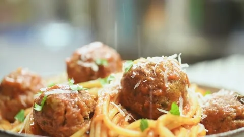 Chef grating parmesan on spaghetti with meatballs. Stock Footage 202072664