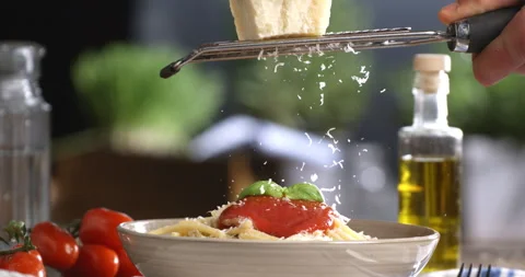 Chef grating parmesan on spaghetti with red tomato sauce in restaurant kitchen Stock Footage 268835714