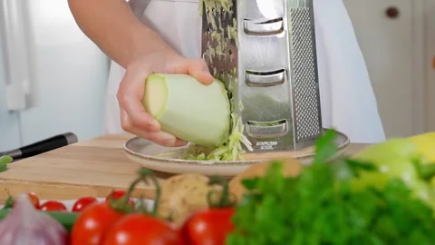 The chef grating white zucchini on a coarse grater Stock Footage 270150385