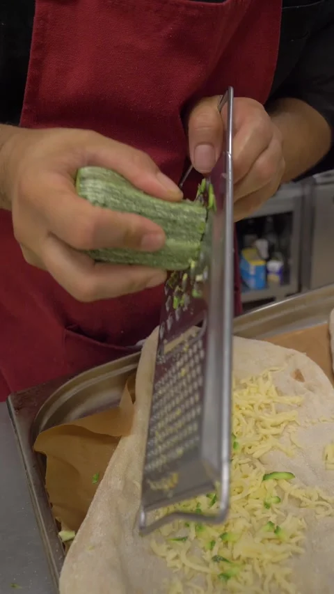Chef grating zucchini over traditional Roman pinsa dough Stock Footage 340151987