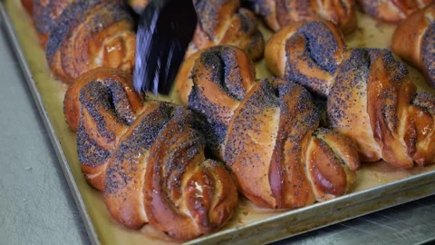 A chef greasing poppy seed buns with butter with a brush in a restaurant kitchen Stock Footage 318659183