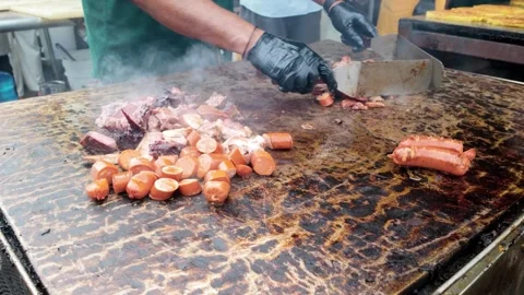Chef griddling pork meat and sausages at dinner party outside - Close up male Video stock 335186160
