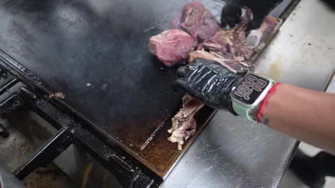 Chef grilling different cuts of meat on a large plancha Stock Footage 323792497