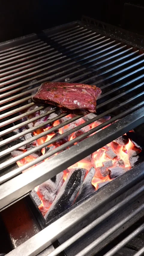 Chef grilling a juicy raw beef steak on a charcoal grill Stock-Footage 327579162