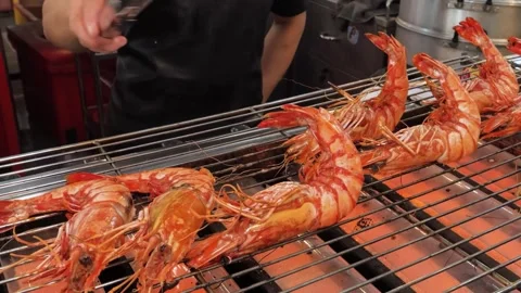 Chef grilling large tiger prawns on an outdoor charcoal BBQ grill Stock-Footage 344220779