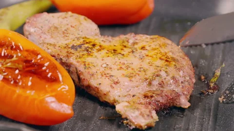 Chef grilling meat and vegetables on a cast iron skillet Stock Footage 162860780