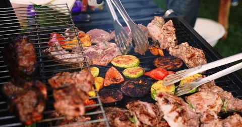 Chef grilling meat and vegetables on grill during summer barbeque party Stock Footage 240168015
