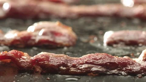 Chef grilling slices of bacon on flattop grill at commercial kitchen. 스톡 동영상 334641596