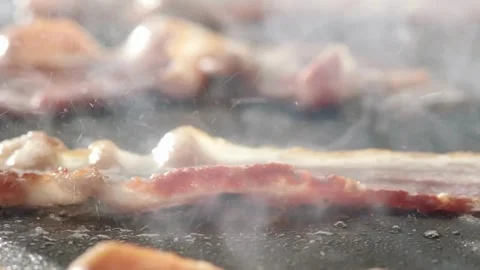 Chef grilling slices of bacon on flattop grill at commercial kitchen. 스톡 동영상 334641695
