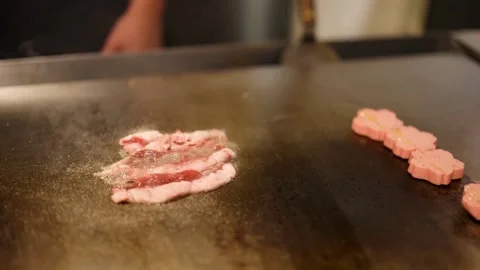 Chef grilling slices of bacon on flattop grill at commercial kitchen. 스톡 동영상 334641820