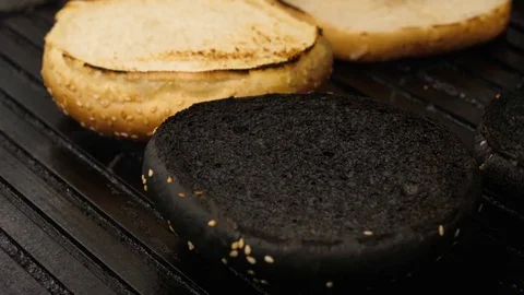 Chef grilling a yellow and black buns for burgers, 4K 60 FPS Stock Footage 76952271