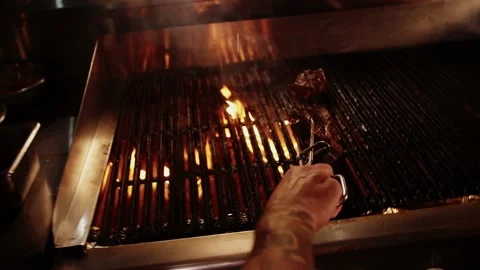 Chef grills the meat in the restaurant kitchen.Man cooks grilled meat. Stock Footage 208630499