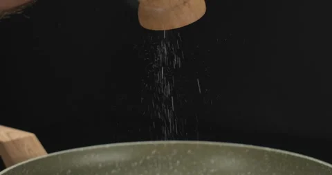 Chef grinding salt with a salt mill. Add salt to fish stea. Salt falls in slow Stock Footage 252750090