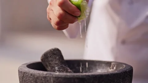 Chef grinds and prepares fresh roasted mexican salsa in a stone molcajete bowl Stock Footage 288038817