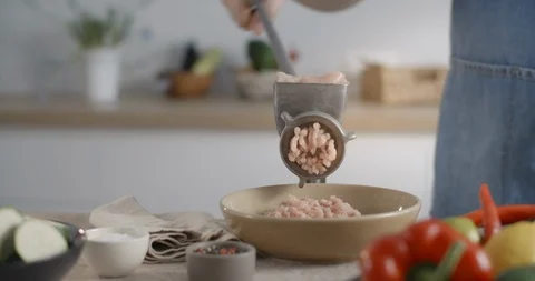 Chef grinds chicken brests in the mechanical grinder at the kitchen, cooking the Stock Footage 127432099