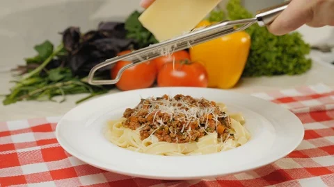 Chef grinds parmesan cheese into a finished dish Stock Footage 124490515