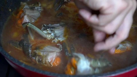 Chef hand adding raw fresh crab with egg in Singapore signature dish chilli c Stock Footage 198971973