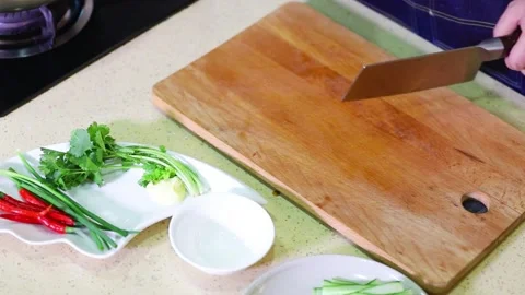Chef hand crushing garlic cloves on wooden cutting board with cleaver. Stock Footage 336327265