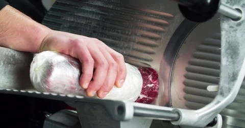 Chef hand cutting raw meat on slice machine 4k сlose up video for carpaccio Stock Footage 70004834