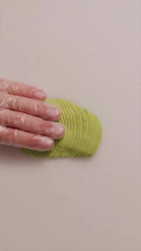 Chef hand flattening thin avocado slices on a cutting board Stock Footage 337119143
