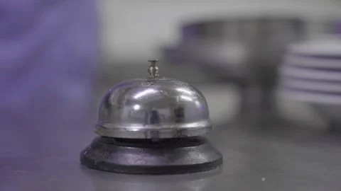 Chef hand in gloves ringing service bell in restaurant kitchen 스톡 동영상 332116300