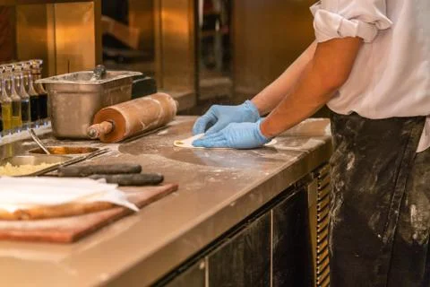 Chef hand making the pizza in kitchen Stock Photos