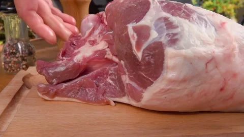 Chef hand placing raw leg of lamb on table for preparation in kitchen Stock Footage 328092989