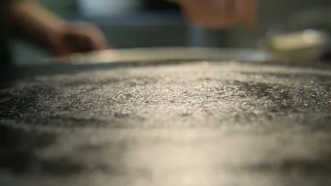A chef hand pours liquid white dough with a scoop on a frying pan and spins it Stock Footage 86594267