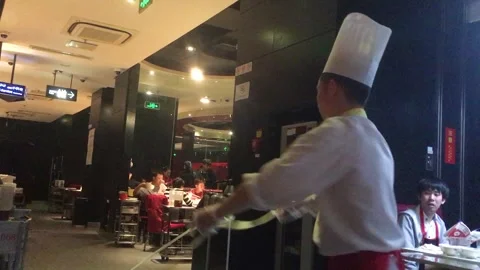 Chef Hand-Pulling Noodles for Diners in Busy Beijing Restaurant Interior Stock Footage 345746235