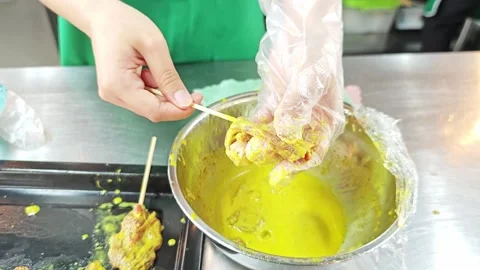 Chef hand skewering raw marinated pork satay over a bowl. Vídeo Stock 343697868