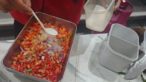 Chef hand sprinkling salt over fresh sliced onions and green chili peppers. Video stock 327652347