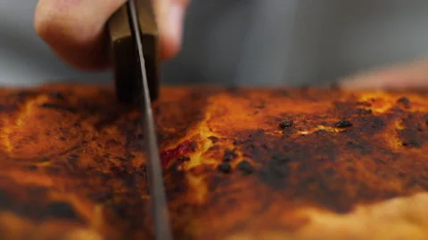 Chef hand taking a delicious piece of pizza with salami pickles cheese on a Stock Footage 136668821