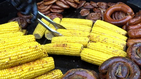 Chef hand turns grilled corn on the counter with grilled sausages. Stock-Footage 102922329